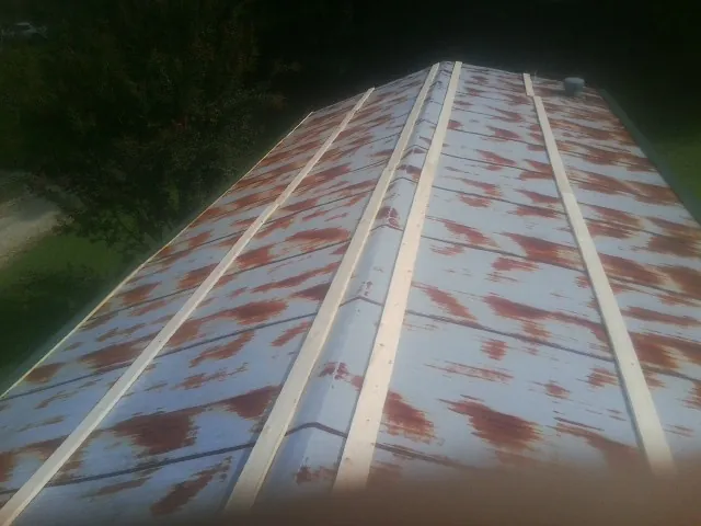 Rusted metal roof panels with new wood purlins before replacement — Storm Damage Roof Repair in Carefree by Roofing Brothers